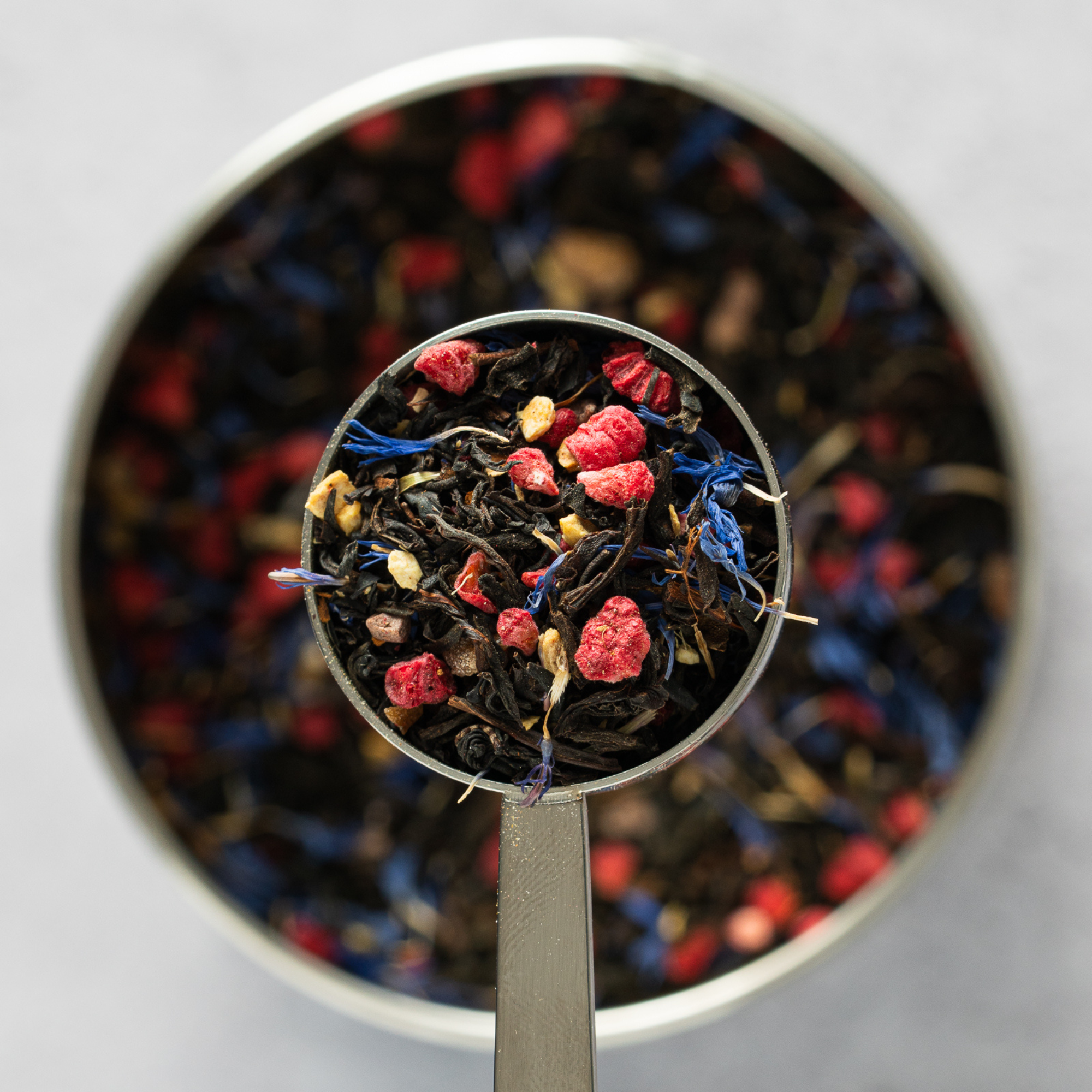 Close up of Billy’s Brew loose leaf black tea with red berries, ginger pieces and blue cornflower petals