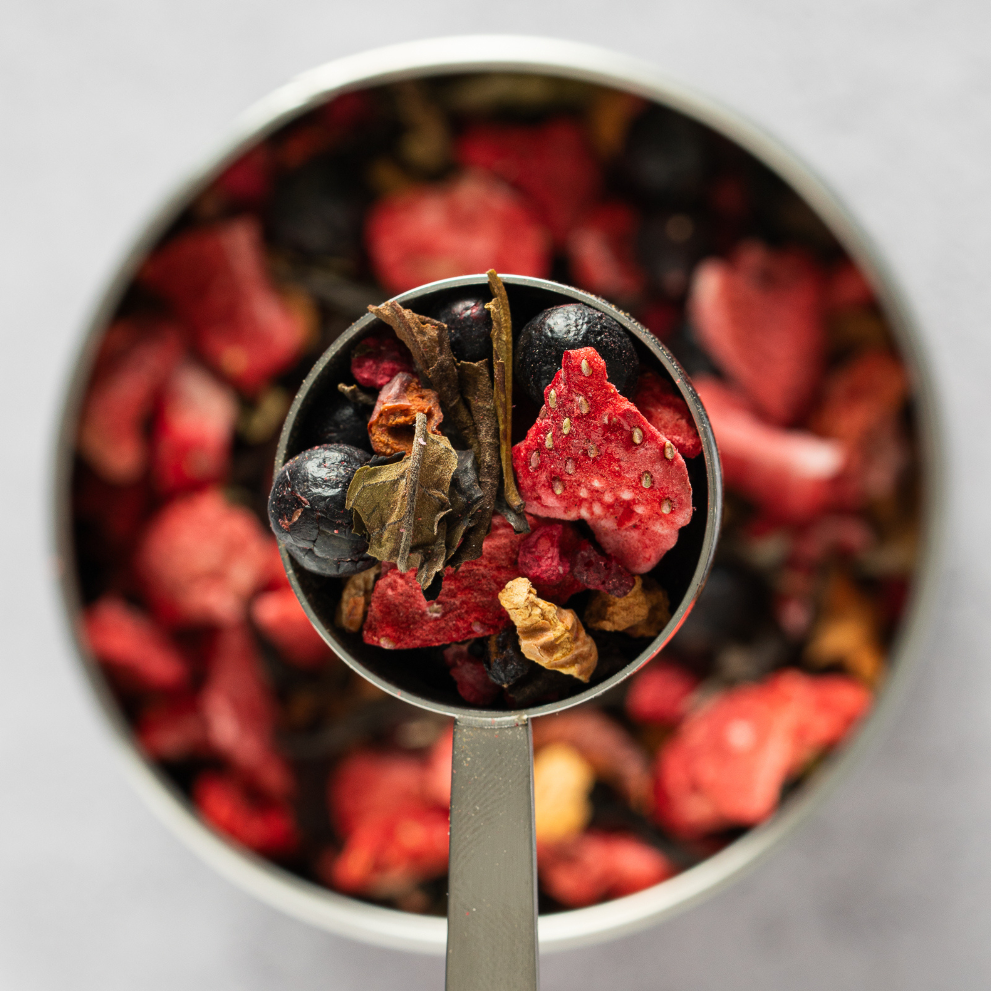 Close-up of Rosy Berry loose leaf tea showing dried strawberries, blueberries and white tea leaves